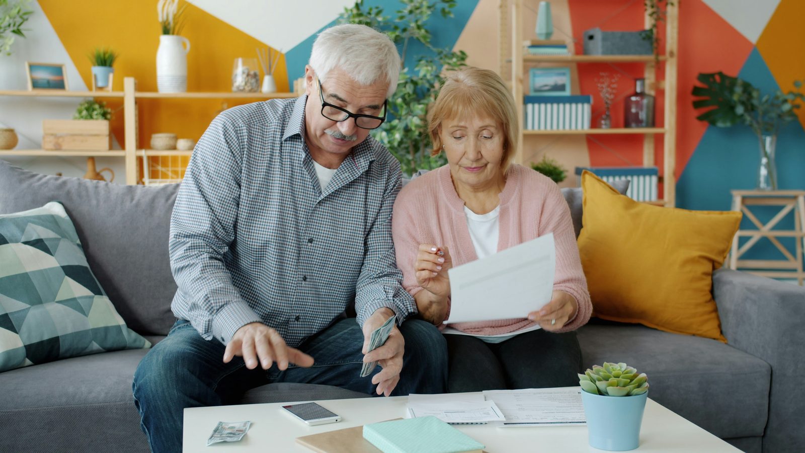 Couple de retraités consultant leurs documents à la maison